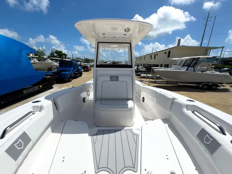 Slide: The Image of 2025 Sea Fox 248 Commander boat interior, white seating, and deck, under a sunny sky. - 19