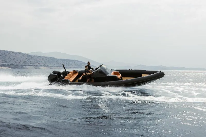 Slide: The Image of Roughneck 1010 boat speeding on water, 2022 model, with scenic coastal background. - 13