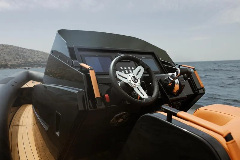 Slide: The Image of 2022 Roughneck 1010 boat dashboard with modern steering and controls on open water. - 17