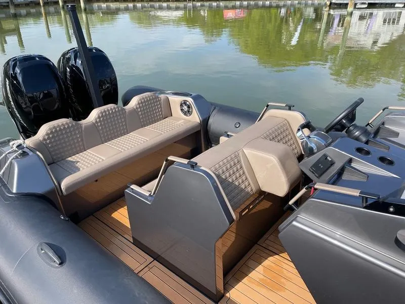Slide: The Image of 2022 Roughneck 1010 boat interior with seating and dual engines on calm water. - 3
