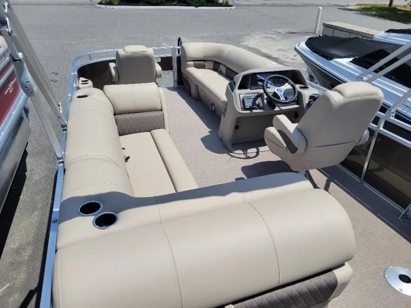 Slide: The Image of 2025 Sun Tracker SF 20 DLX pontoon boat interior with beige seating and steering console. - 11