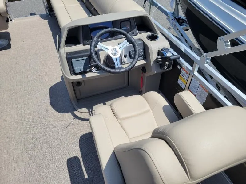 Slide: The Image of 2025 Sun Tracker SF 20 DLX boat interior with steering console and beige seating. - 12