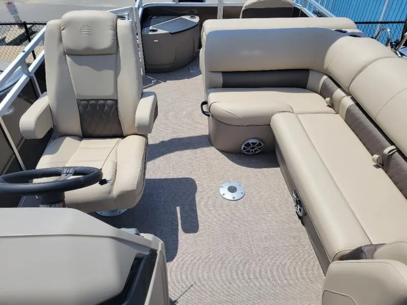 Slide: The Image of 2025 Sun Tracker SF 20 DLX pontoon boat interior with beige seating and steering console. - 7
