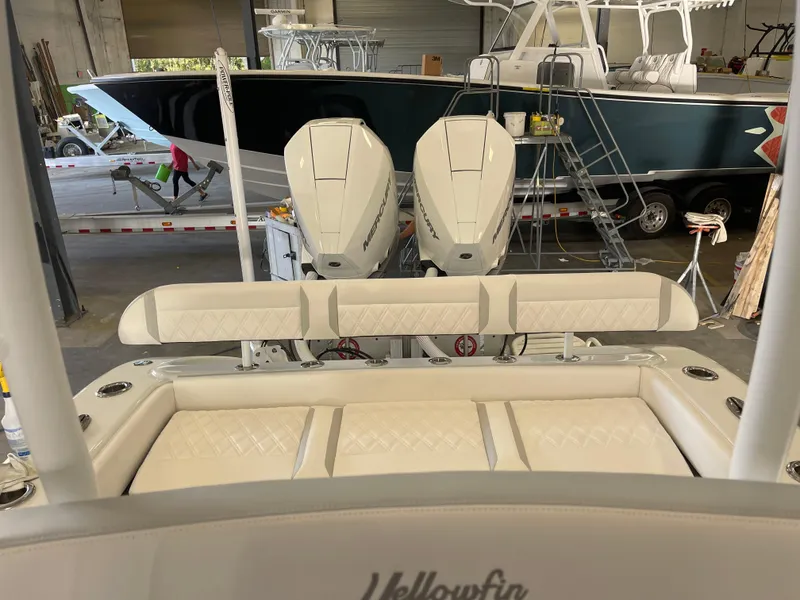 Slide: The Image of 2025 Yellowfin 26 Hybrid boat with twin outboard engines in a showroom. - 13