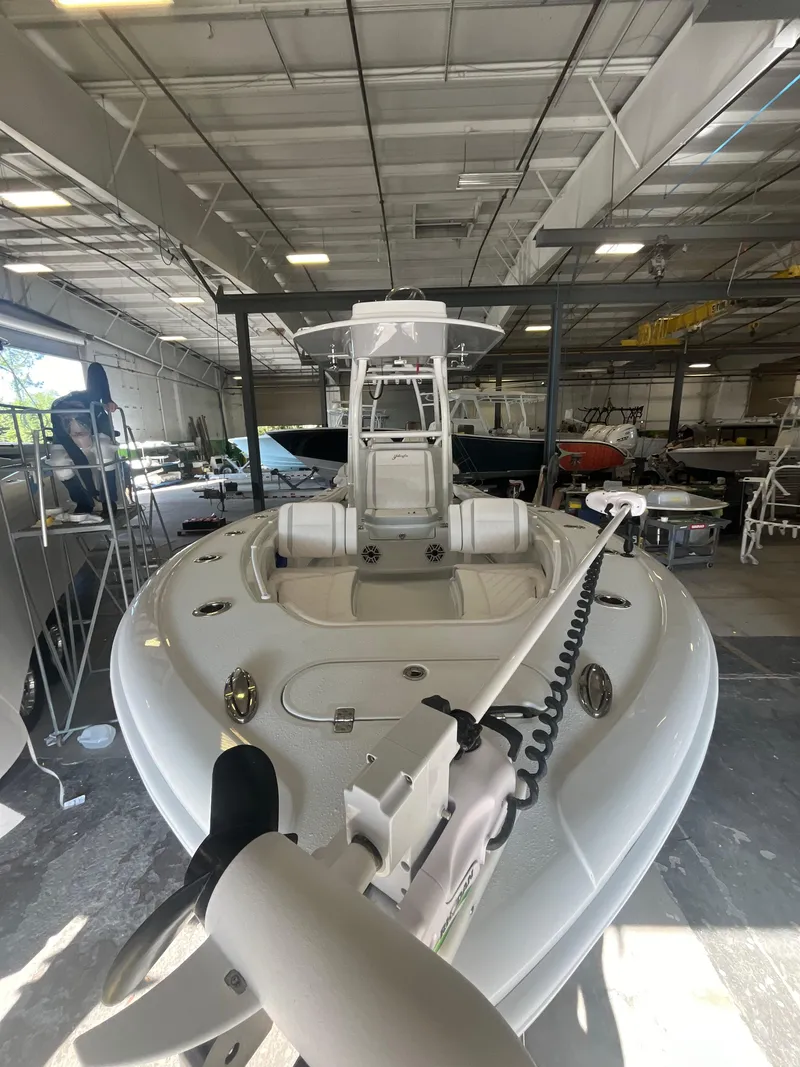 Slide: The Image of 2025 Yellowfin 26 Hybrid boat in a warehouse. - 2