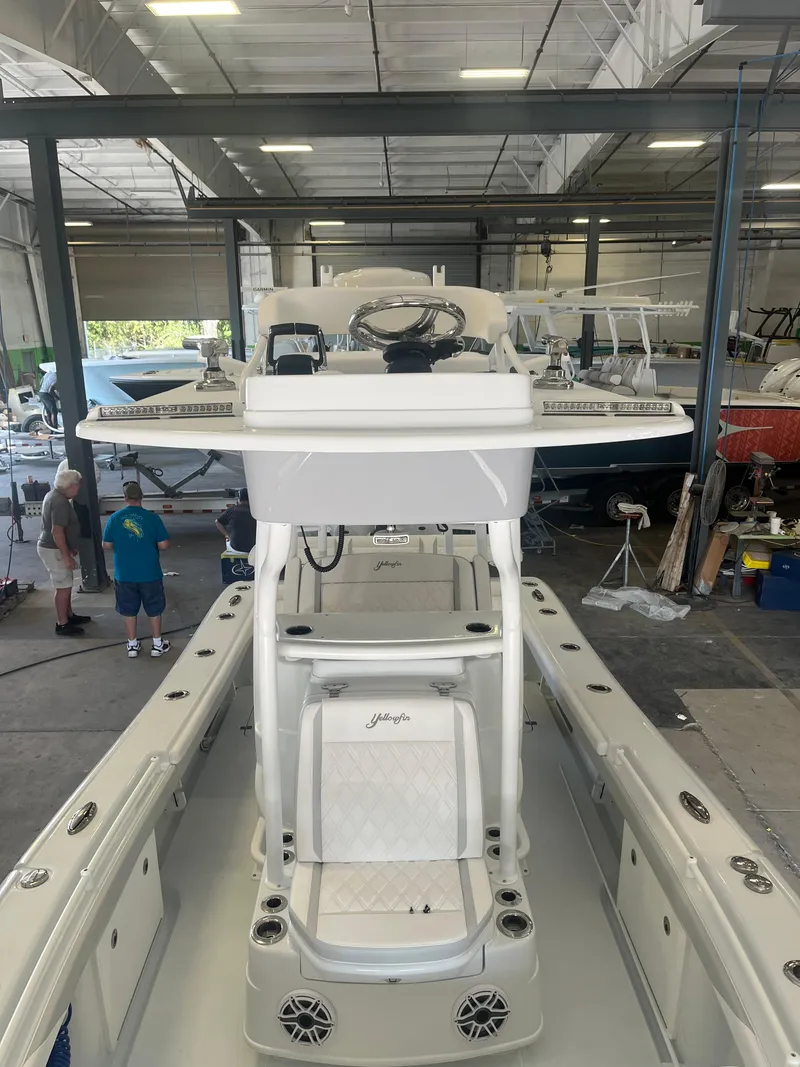 Slide: The Image of 2025 Yellowfin 26 Hybrid boat in a warehouse, interior view. - 3