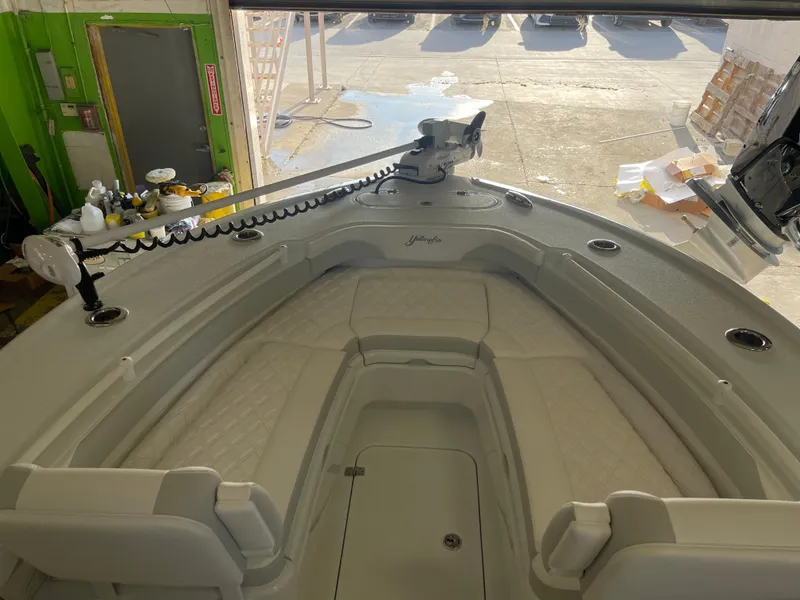 Slide: The Image of 2025 Yellowfin 26 Hybrid boat interior with cushioned seating and mounted equipment. - 5