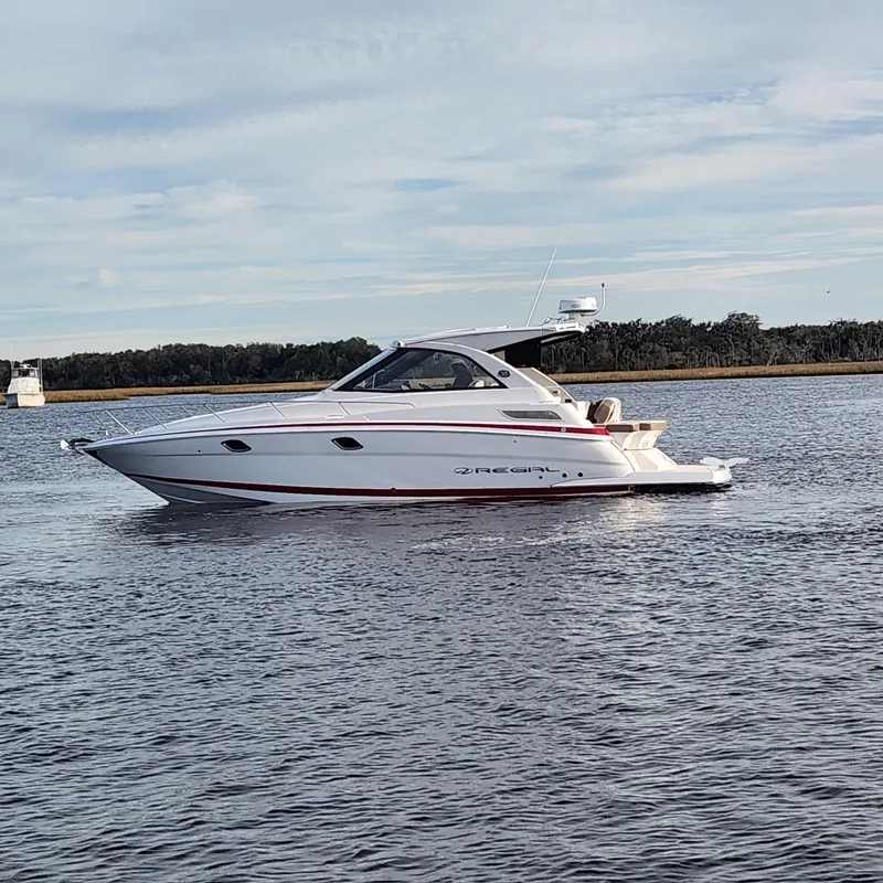 Slide: The Image of 2018 Regal 35 Sport Coupe boat cruising on a calm lake. - 1