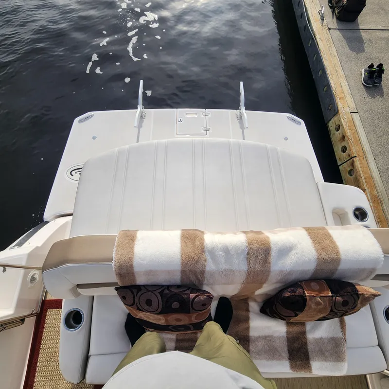Slide: The Image of 2018 Regal 35 Sport Coupe boat stern with cushions and blanket, docked at marina. - 14