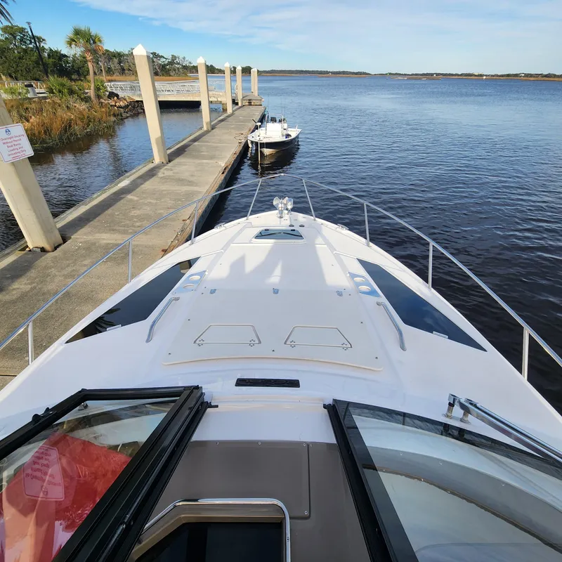Slide: The Image of 2018 Regal 35 Sport Coupe docked at a marina with a scenic water view. - 15