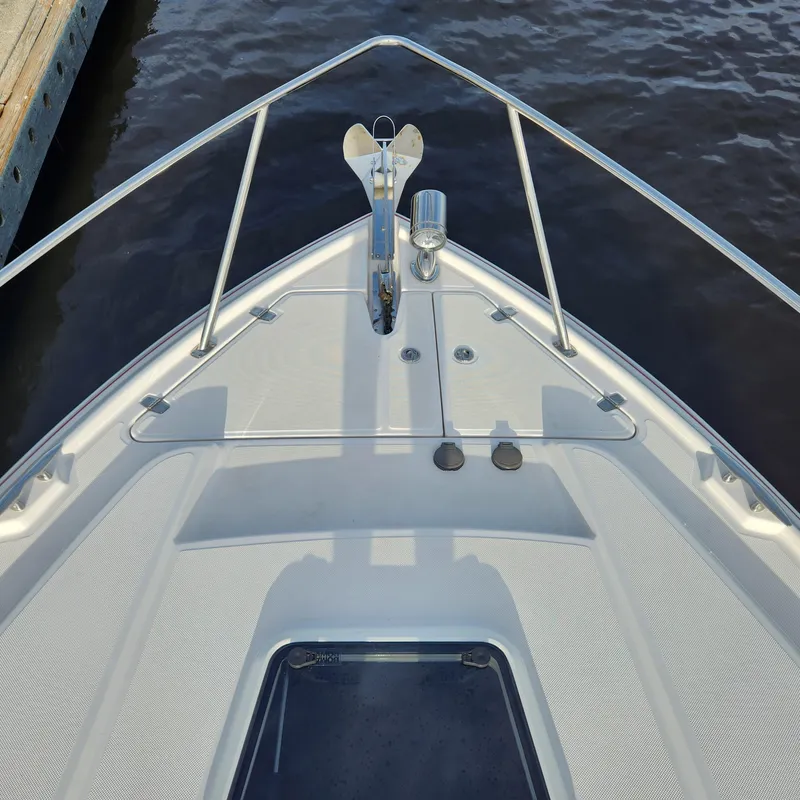 Slide: The Image of Bow of 2018 Regal 35 Sport Coupe at dock, showing anchor and deck details. - 16