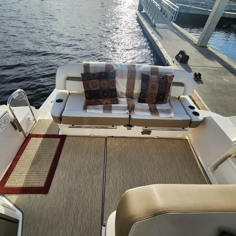 Slide: The Image of 2018 Regal 35 Sport Coupe boat interior with cushioned seating and decorative pillows. - 26