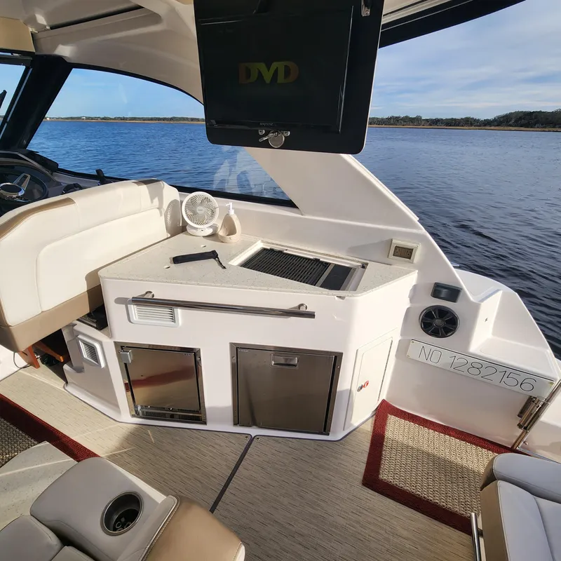 Slide: The Image of Interior of a 2018 Regal 35 Sport Coupe boat with kitchenette and DVD player. - 28