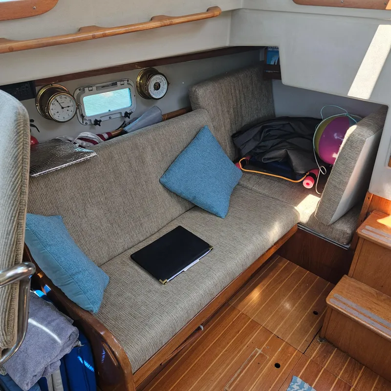 Slide: The Image of Cozy interior of 1986 Nautilus Pilothouse 36 with seating, pillows, and nautical instruments. - 19