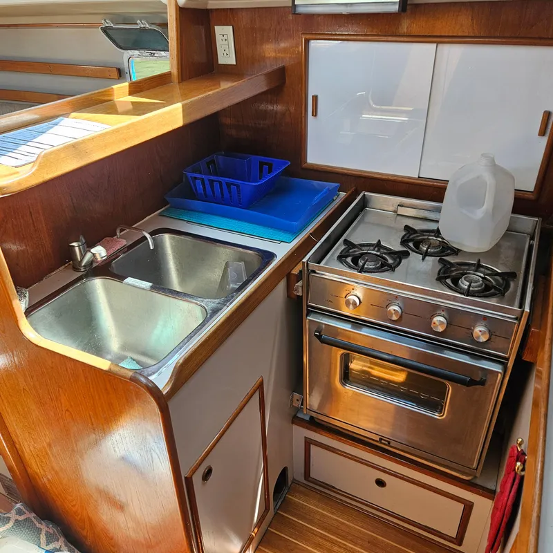 Slide: The Image of Compact kitchen in 1986 Nautilus Pilothouse 36 with stove, sink, and wooden cabinetry. - 21