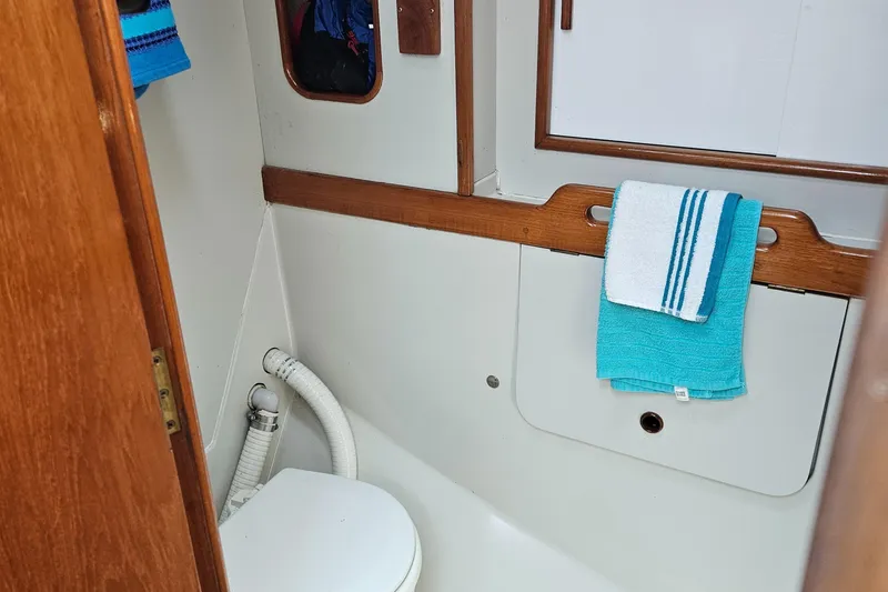Slide: The Image of 1986 Nautilus Pilothouse 36 bathroom with white toilet and blue towels. - 31