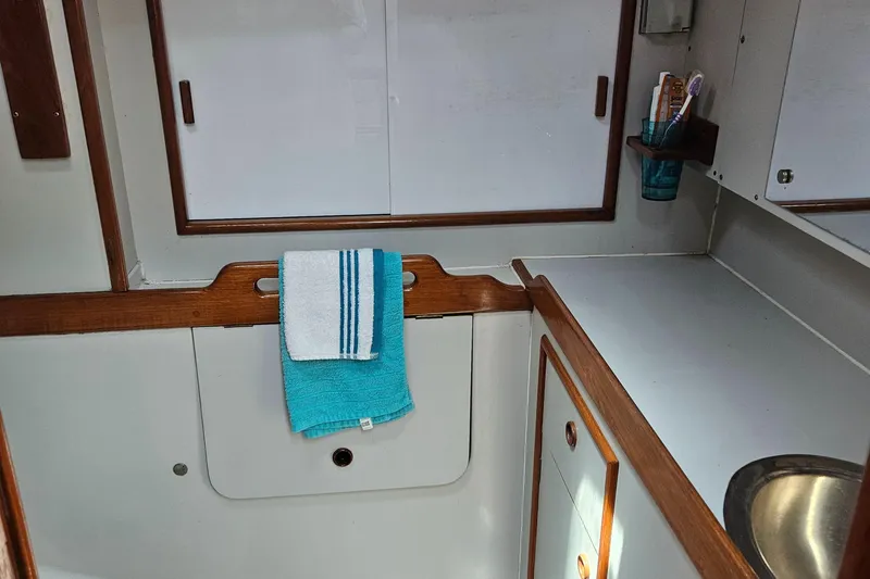 Slide: The Image of 1986 Nautilus Pilothouse 36 interior with white cabinetry and teal towel. - 32