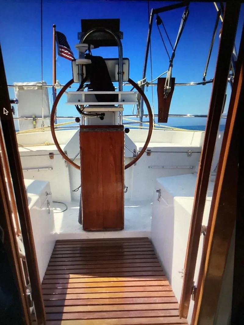 Slide: The Image of 1986 Nautilus Pilothouse 36 yacht cockpit with wooden wheel and deck, open sea view. - 35