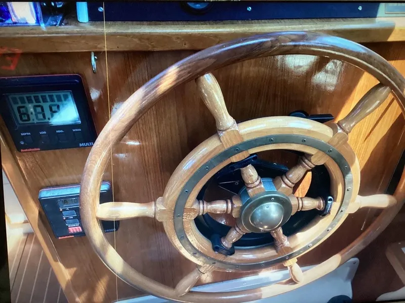 Slide: The Image of Wooden steering wheel of 1986 Nautilus Pilothouse 36 boat, with control panel. - 37