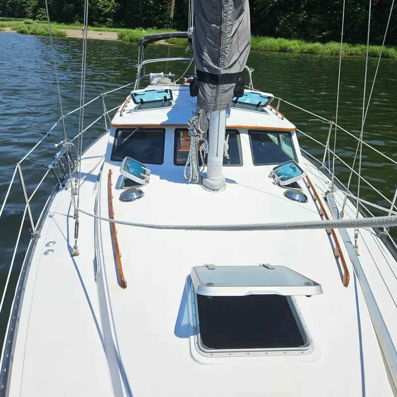 Slide: The Image of 1986 Nautilus Pilothouse 36 sailboat on calm water, showcasing deck and cabin details. - 41