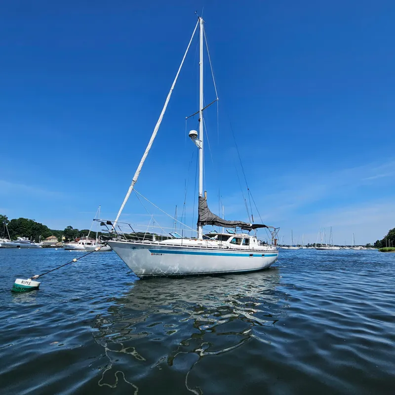 Slide: The Image of 1986 Nautilus Pilothouse 36 sailboat on calm water under clear blue sky. - 5