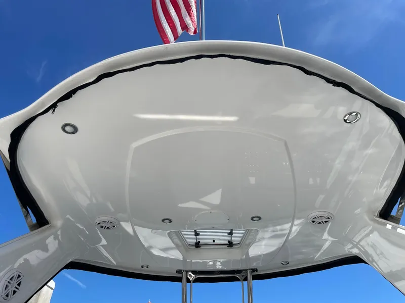 Slide: The Image of Monterey 345 Sport Yacht 2020, sleek white roof, American flag, blue sky background. - 17