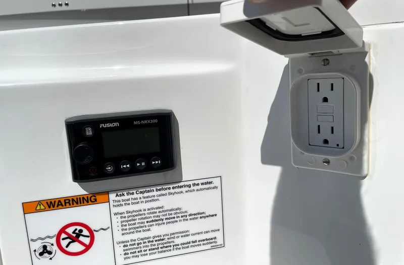 Slide: The Image of Control panel and outlet on 2020 Monterey 345 Sport Yacht with safety warning label. - 31