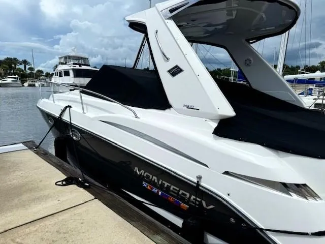 Slide: The Image of 2020 Monterey 345 Sport Yacht docked at marina, sleek design, black and white exterior. - 6
