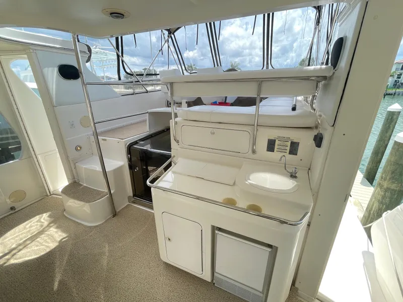 Slide: The Image of 1998 Sea Ray 420 Aft Cabin interior with kitchenette, sink, and seating area. - 11
