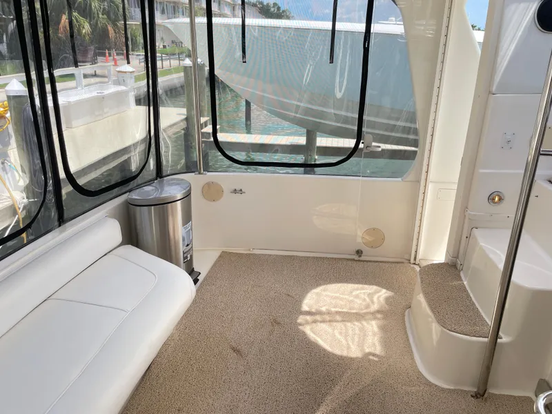 Slide: The Image of 1998 Sea Ray 420 Aft Cabin interior with seating, steps, and marina view. - 13
