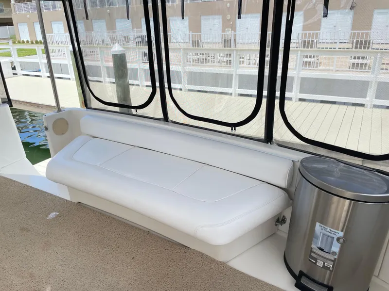 Slide: The Image of 1998 Sea Ray 420 Aft Cabin interior with white seating and stainless steel trash can. - 15