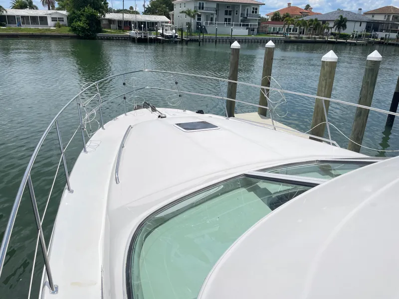 Slide: The Image of 1998 Sea Ray 420 Aft Cabin yacht docked in a serene waterfront setting. - 22