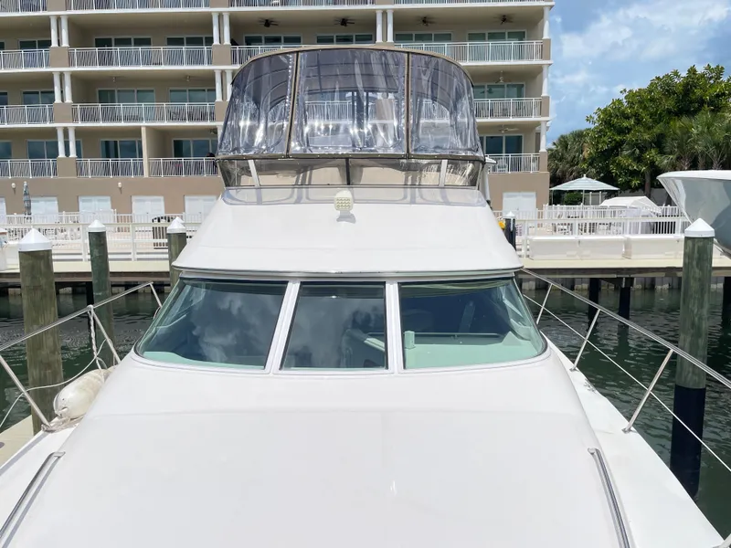 Slide: The Image of 1998 Sea Ray 420 Aft Cabin yacht docked near waterfront building. - 23
