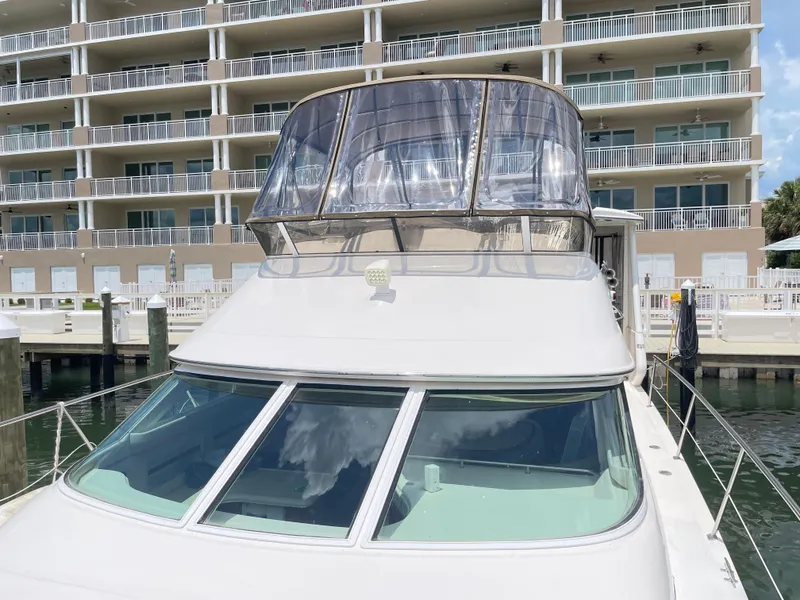 Slide: The Image of 1998 Sea Ray 420 Aft Cabin yacht docked near modern waterfront building. - 25