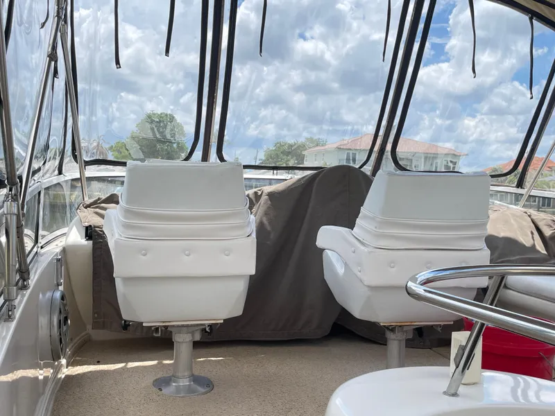 Slide: The Image of 1998 Sea Ray 420 Aft Cabin interior with white seats and clear canopy. - 27