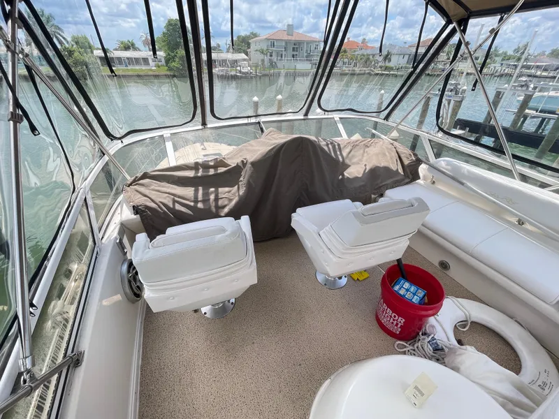 Slide: The Image of 1998 Sea Ray 420 Aft Cabin boat interior with chairs and covered equipment. - 28