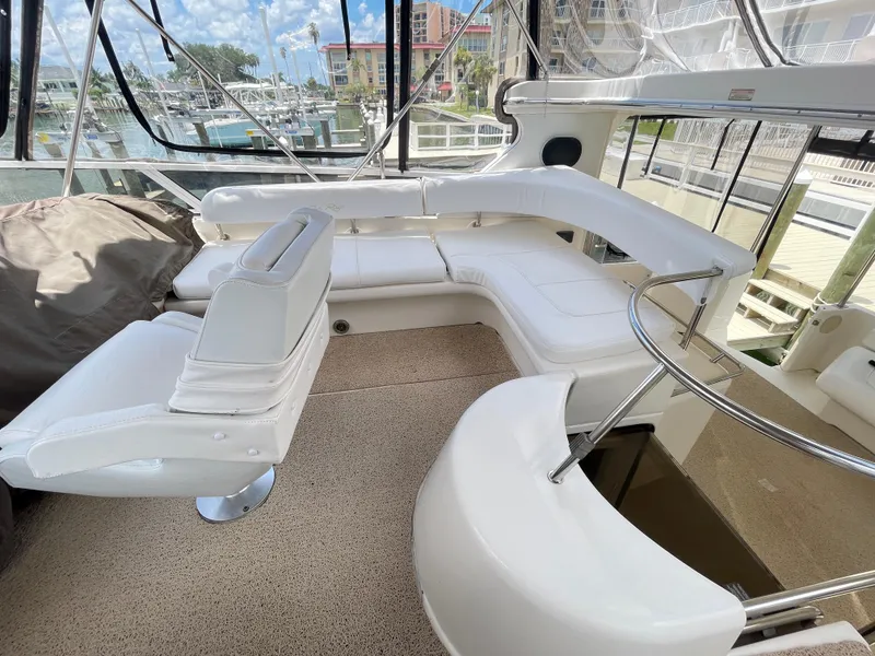 Slide: The Image of 1998 Sea Ray 420 Aft Cabin yacht interior with white seating and marina view. - 30