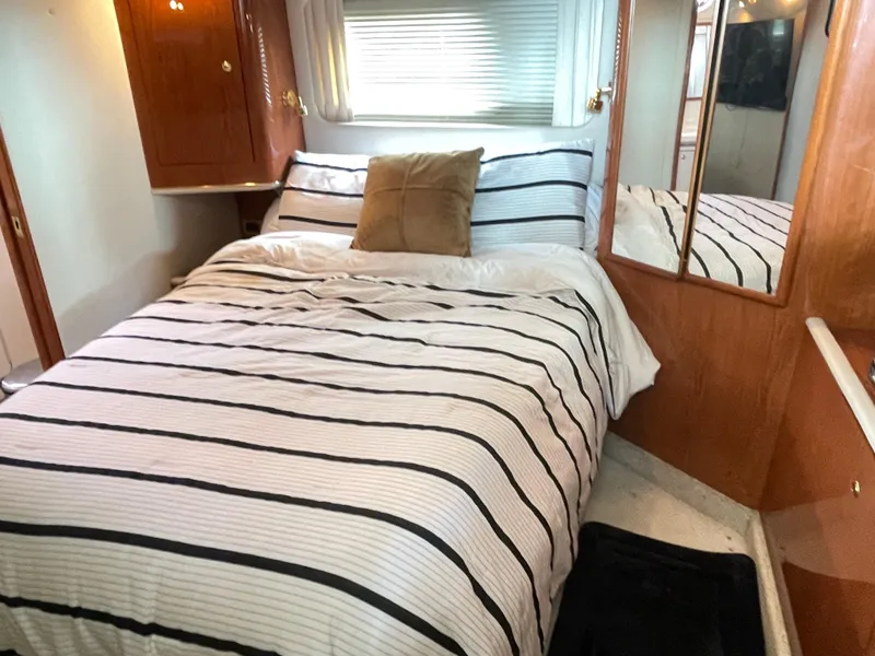 Slide: The Image of Cozy bedroom in 1998 Sea Ray 420 Aft Cabin with striped bedding and wooden accents. - 44