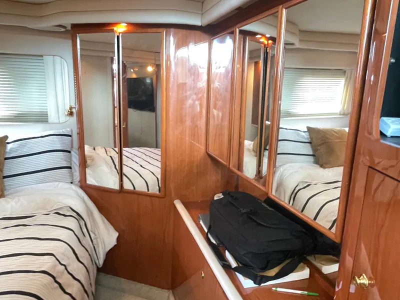 Slide: The Image of 1998 Sea Ray 420 Aft Cabin interior with striped bedding and mirrored cabinets. - 45