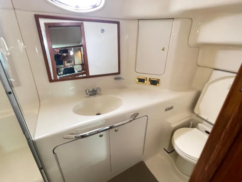 Slide: The Image of 1998 Sea Ray 420 Aft Cabin bathroom with sink, mirror, and toilet. - 49