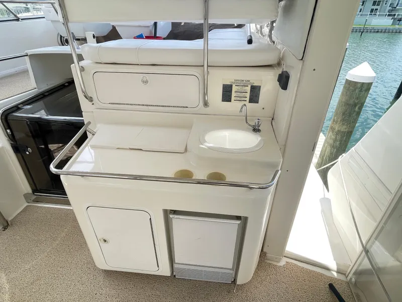 Slide: The Image of 1998 Sea Ray 420 Aft Cabin yacht kitchenette with sink and storage, dockside view. - 8