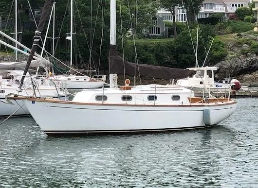 The Image of 1983 Cape Dory 28 sailboat docked in a serene marina setting. - 0
