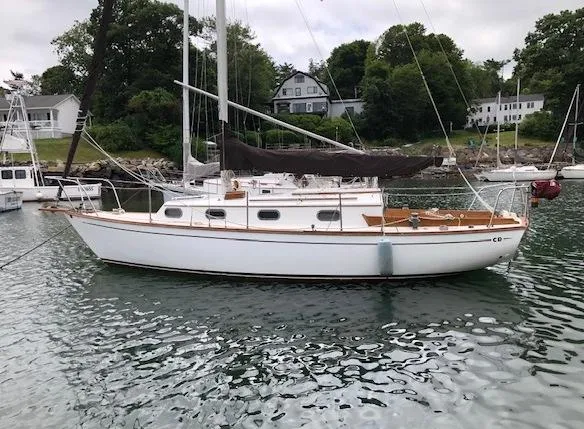 Slide: The Image of 1983 Cape Dory 28 sailboat anchored in a scenic harbor. - 1