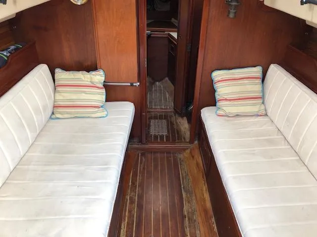 Slide: The Image of Interior of 1983 Cape Dory 28 sailboat with wooden flooring and cushioned seating. - 11