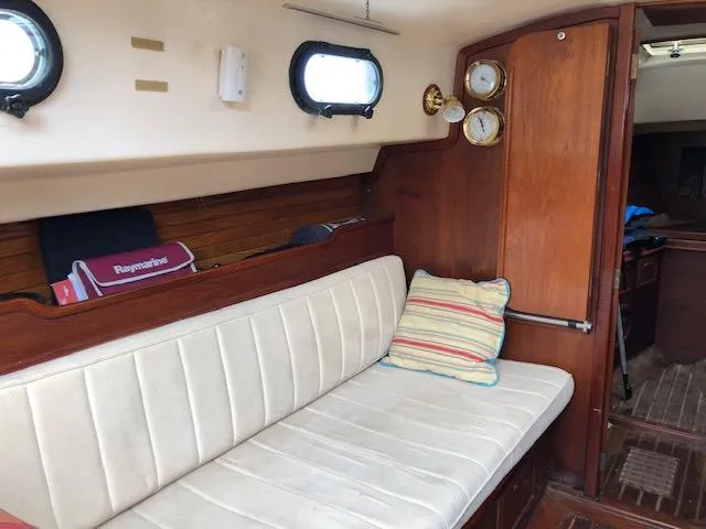 Slide: The Image of Interior of a 1983 Cape Dory 28 sailboat with cushioned seating and wooden accents. - 13