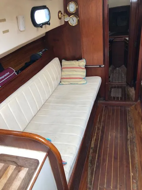 Slide: The Image of 1983 Cape Dory 28 sailboat interior with wooden flooring and cushioned seating. - 15