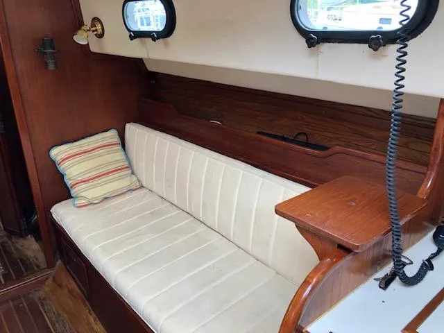Slide: The Image of Interior of 1983 Cape Dory 28 sailboat with cushioned seating and wooden accents. - 17
