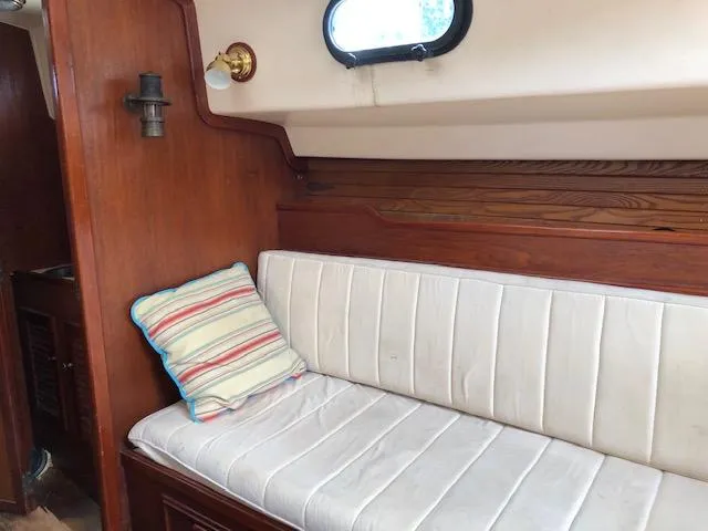 Slide: The Image of Interior of 1983 Cape Dory 28 sailboat with cushioned seating and striped pillow. - 18