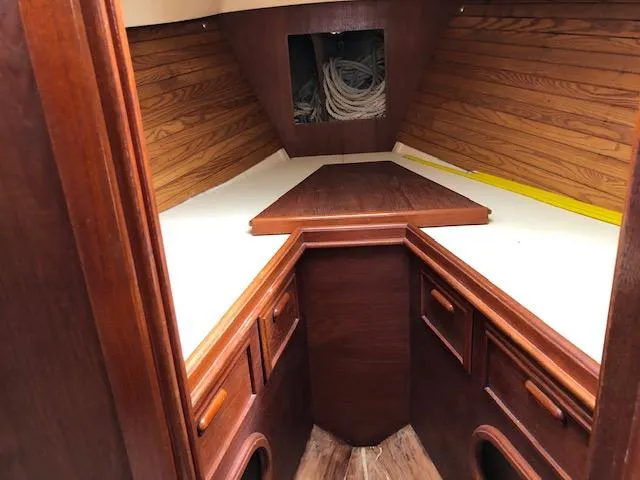 Slide: The Image of 1983 Cape Dory 28 interior cabin with wooden finish and storage compartments. - 28