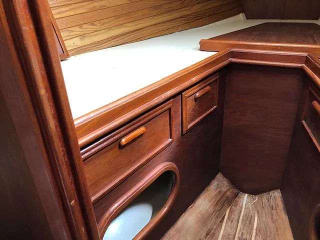 Slide: The Image of 1983 Cape Dory 28 interior with wooden cabinetry and storage compartments. - 29